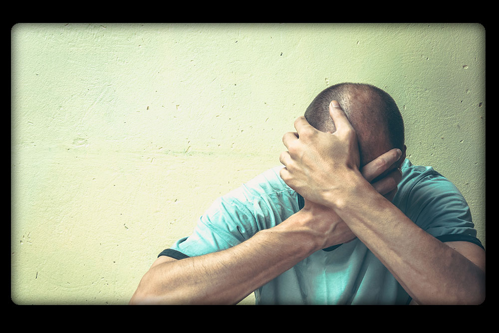 Man in anguish against a wall